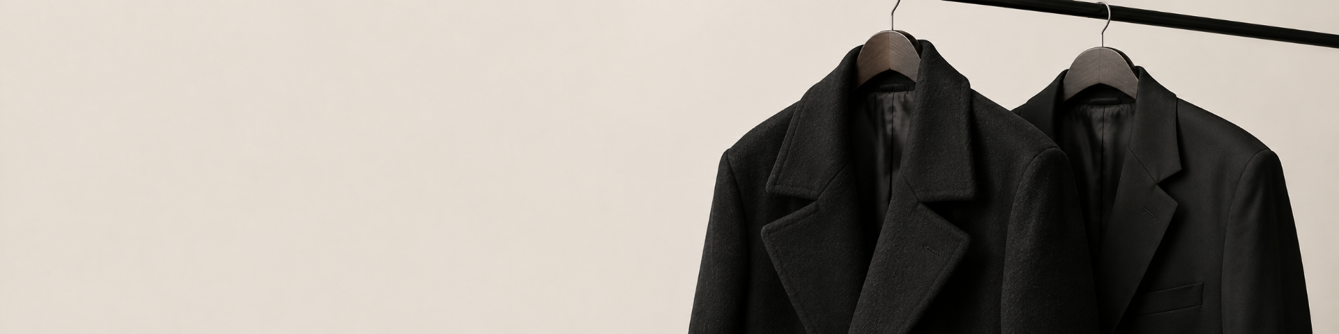 Schwarzer Designer-Mantel auf Kleiderbügel im editorial crop